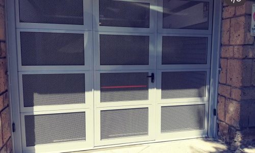 Porta sezionale a rete stiarata con porta pedonale